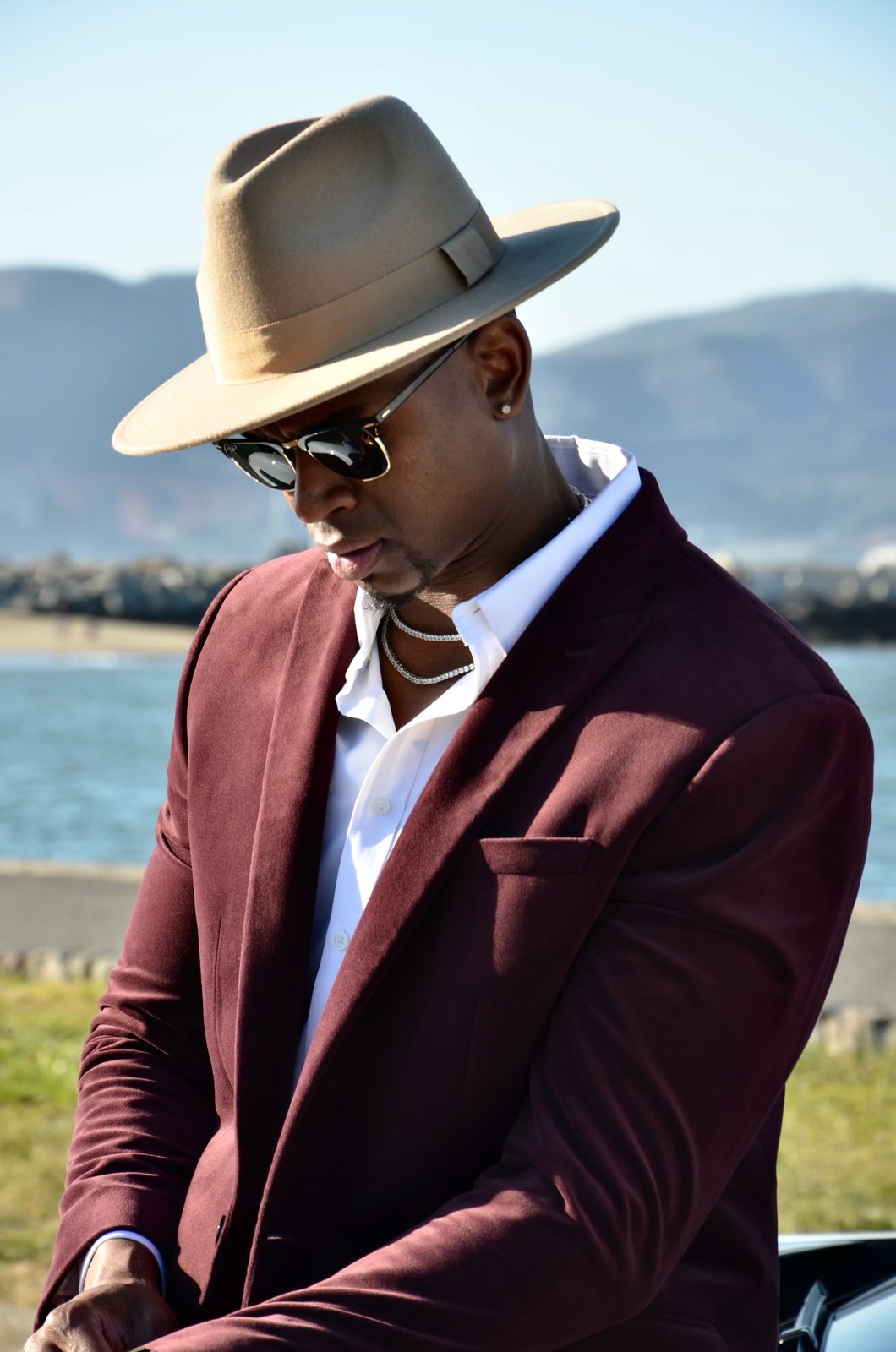 Michael K. Farley standing by the water in a hat and suit